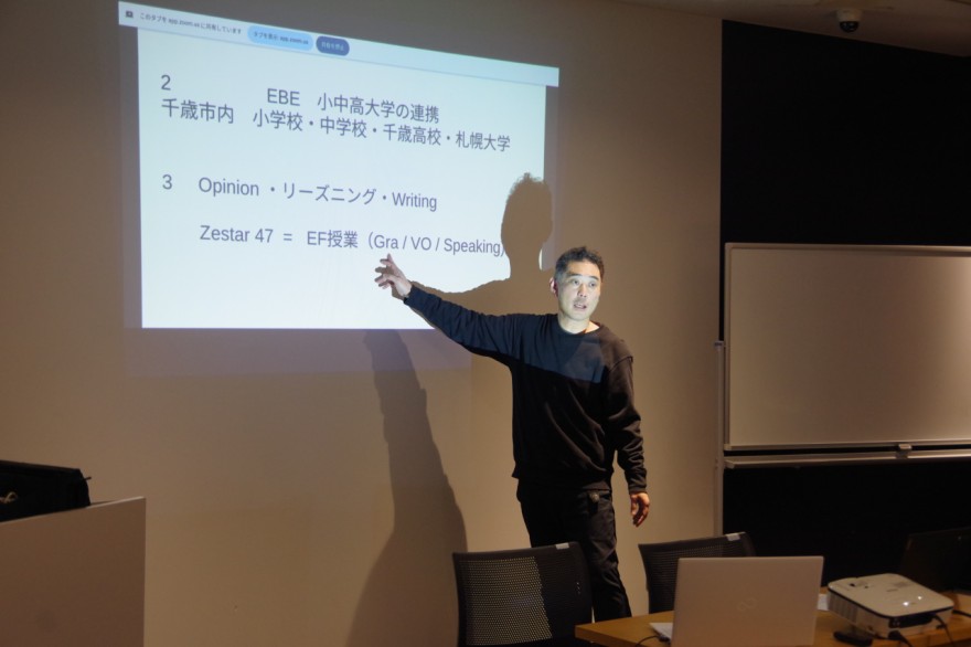 授業手法や語学研修について報告する小林教諭