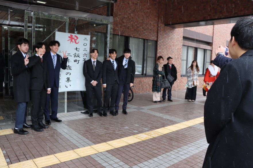 仲間と笑顔で記念撮影するスーツ姿の男性陣（七飯町）