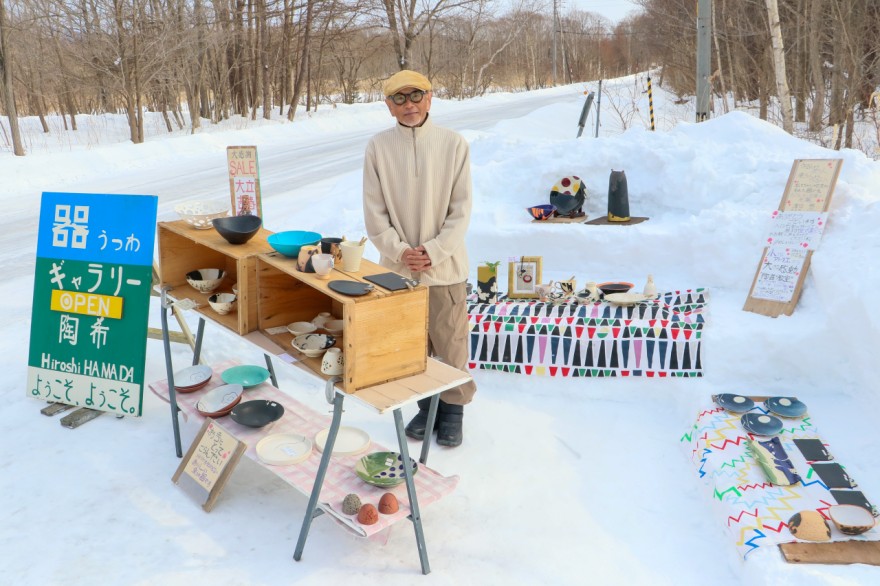 雪上に並べた器やカップなどを紹介する浜田さん