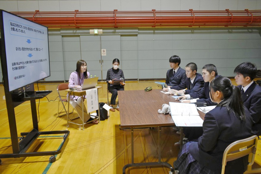 講師（左端）の話を聞く生徒たち