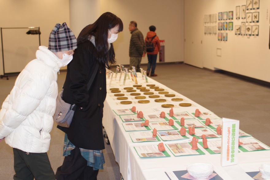 子どもたちが制作した埴輪（はにわ）や陶芸作品に見入る来場者