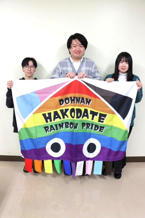 イカをモチーフにした虹色のフラッグを手にする笠島代表（中央）らＤＲＰメンバー