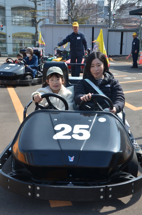 ２人乗りゴーカートを運転する親子