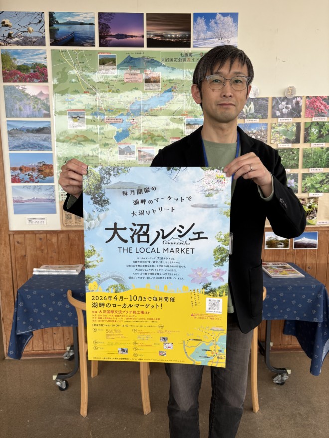 ポスターを手に人の来場を呼びかけるスタッフ