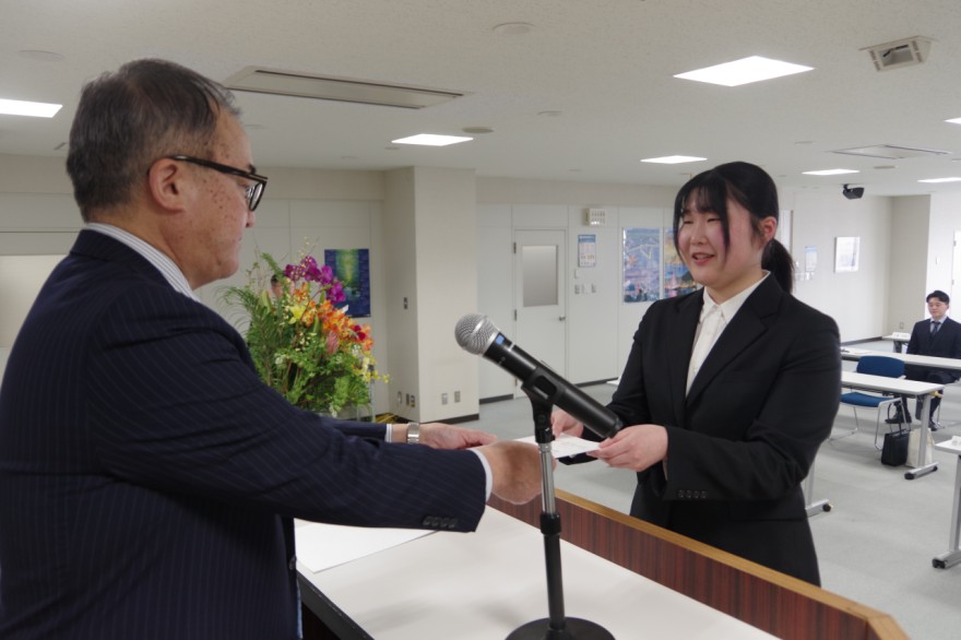 柳原社長（左）から辞令を受け取る新入社員