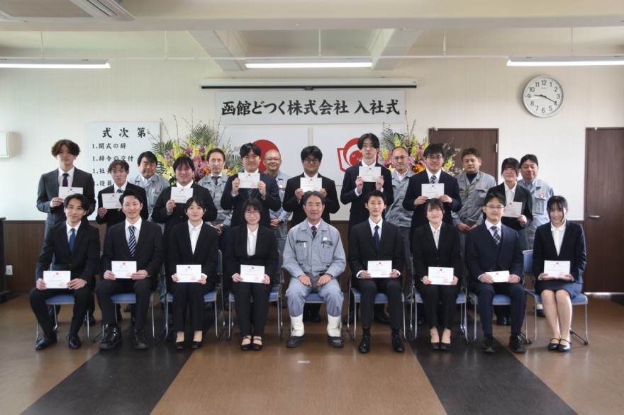 集合写真を撮る新入社員と会社役員