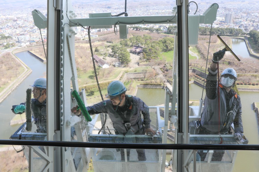 窓ガラスの汚れを手作業で落とす作業員（１４日午前１０時ごろ）